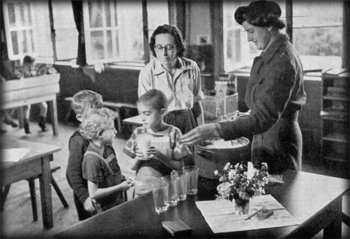 Rehabilitating the children after the liberation; Miss Reekie hands out glasses of milk 